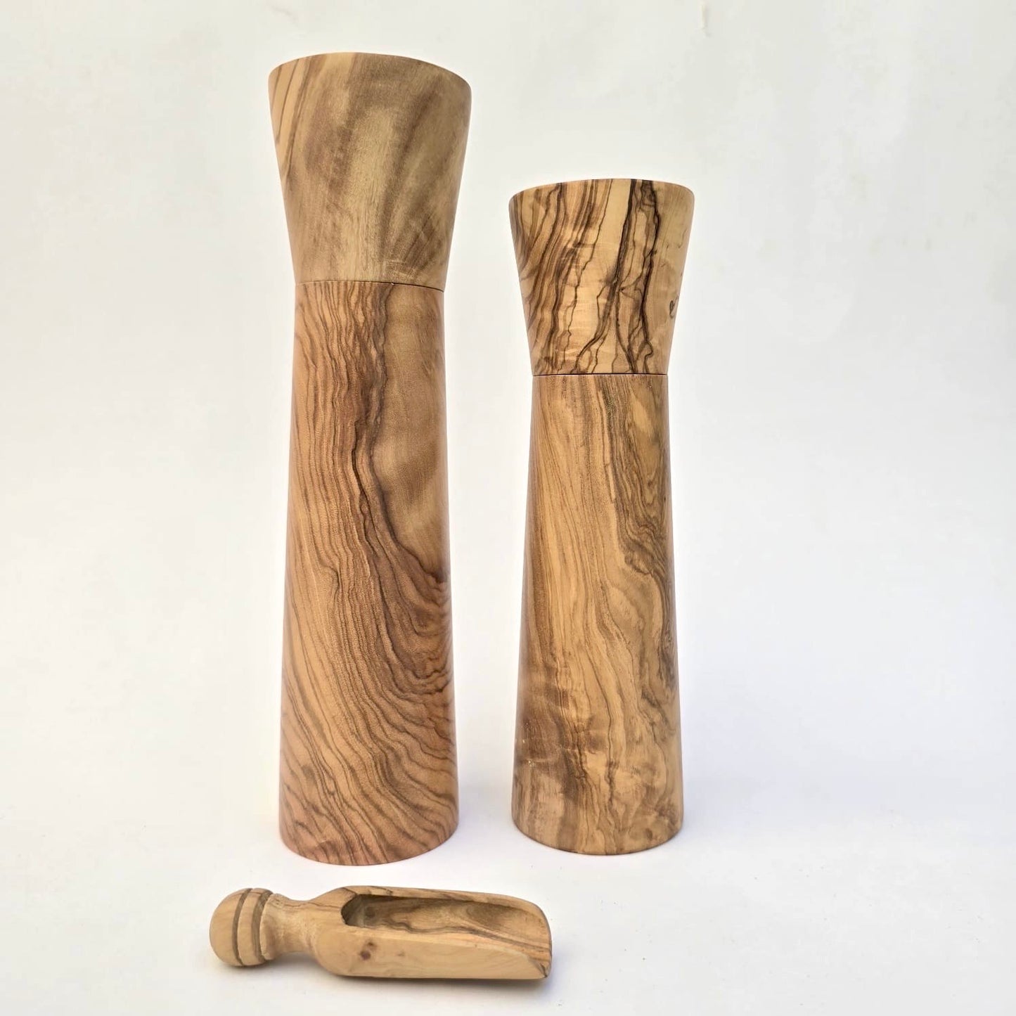 Wooden salt and pepper shakers with a scoop on a white background