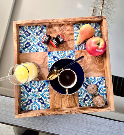 Wooden tray with a checkered pattern containing a cup, a juice glass, and fruits.