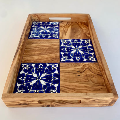 Wooden tray with blue and white patterned tiles on a white background