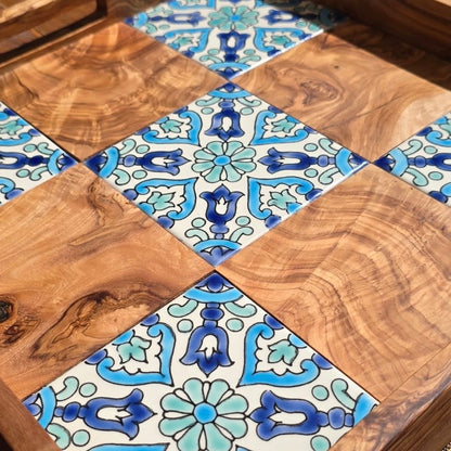 Checkered pattern of wooden and ceramic tiles with blue and green floral designs.